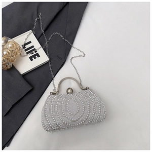 Detail of evening clutch bag with circular pearl patterns and silver chain strap