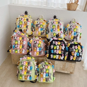 Colorful canvas backpacks with cartoon plush toys in various pastel shades for school
