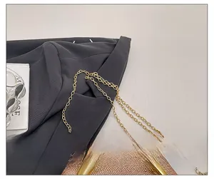 Detail of pink glitter evening bag with gold chain strap and metallic arc frame