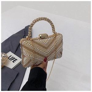 Detail of luxury pearl evening bag with champagne gold rhinestones and beaded handle