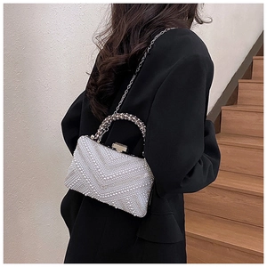 Detailed view of pearl evening clutch with sparkling rhinestones and crystal handle