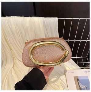 Detail of rose gold rhinestone evening clutch with a bold C-shaped metal top handle