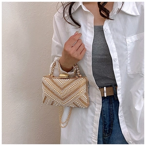 Detail of evening clutch bag with white pearls and rhinestones in V-pattern
