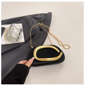 Detail of black rhinestone evening bag with elegant gold metal buckle and chain