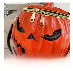 Detail of glossy orange pumpkin bag showing golden dual zippers and patent leather texture