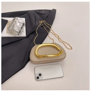 Detail of champagne gold evening clutch with sparkling crystals and a bold metal handle