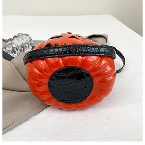 Detailed close-up of orange patent leather pumpkin bag with black crocodile texture base