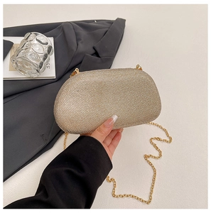 Close-up of champagne gold rhinestone evening clutch with fine metal chain strap