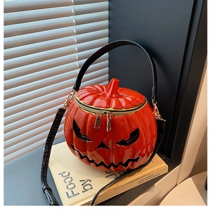 Close-up of gloss pumpkin bag with devil face detail and black crocodile pattern strap