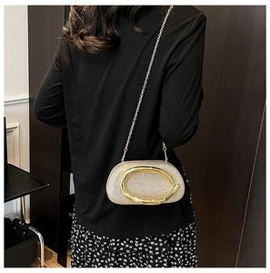 Detail of champagne gold sequin evening bag with large gold horseshoe hardware and chain strap