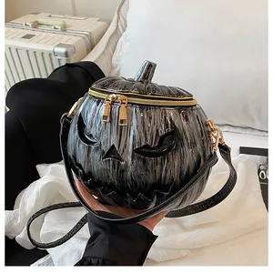 Detail of Jack-o'-lantern face on black pumpkin shoulder bag with gold zipper hardware