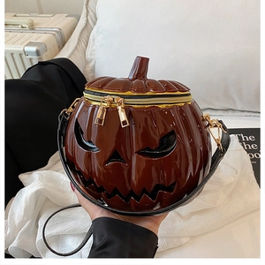 Detail of the glossy pumpkin cross-body bag with devil face cut-outs and golden zippers