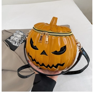 Top view of bright orange pumpkin crossbody bag with glossy finish and black face detail