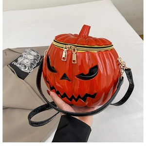 Detail of the pumpkin-shaped crossbody bag with smooth orange finish and gold hardware