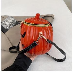 Detail of pumpkin crossbody bag with glossy orange finish and black crocodile strap