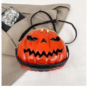Detail of glossy orange pumpkin crossbody bag with black crocodile pattern strap and gold zipper