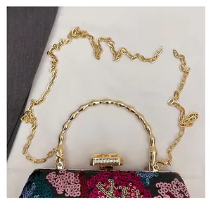 Detail der Paillettenstickerei auf Blumen-Abendtasche mit goldenem Bambusgriff und Kette