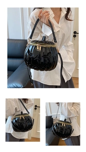 Detail of Jack-o'-lantern black patent leather pumpkin bag with gold zipper and handle