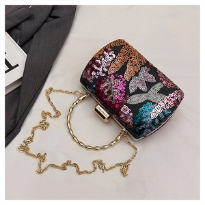 Detailed macro view of sparkling sequins and golden bamboo-style handle on the evening bag
