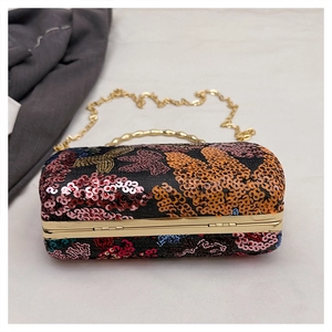 Macro detail of colorful floral sequins and golden metal frame on luxury evening clutch