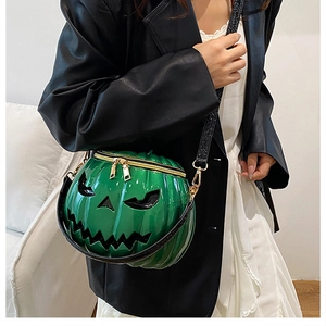 Detail of green pumpkin crossbody bag with gold zippers and black crocodile strap