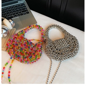 Flat lay of colorful mixed beads and silver metallic woven handbags with chain straps