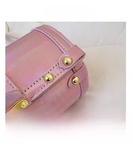 Macro d'un sac rose en cuir laser avec serrure dorée et détails de rivets précis