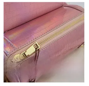 Gros plan sur cuir rose laser à motif crocodile avec fermeture éclair en métal doré