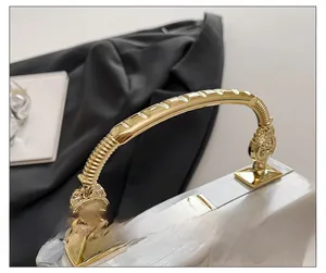 Detail showing marble texture acrylic box bag with golden metal handle and clasp