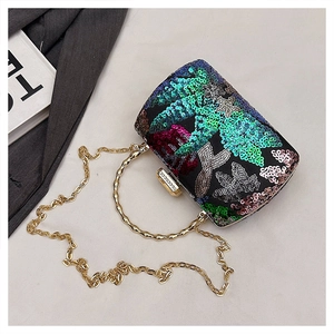 Macro view of colorful sequin evening clutch with golden ring handle and chain strap