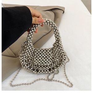 Close-up of silver beaded handbag showing intricate handmade weaving and metallic texture