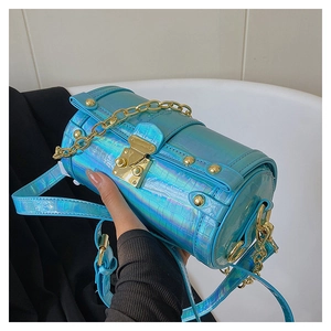 Détail macro du motif crocodile holographique et des ferrures dorées sur le sac
