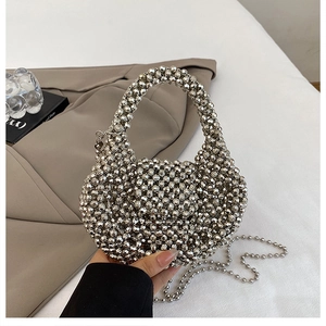 Detail of silver beaded handbag with handcrafted texture and detachable metal chain strap