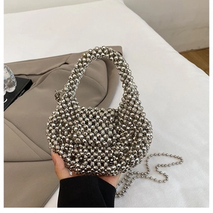 Close-up of the silver beaded weave pattern and metallic texture on the handbag