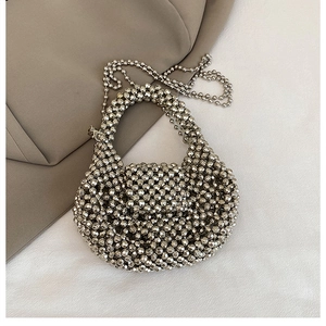 Detail of handcrafted silver beaded crossbody bag featuring a faceted metallic luster finish