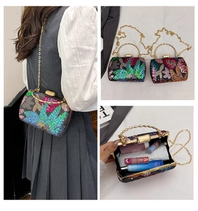 Detailansicht der Abendtasche mit Blumenstickerei, goldenem Bambusgriff und Kette