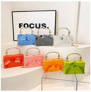 Group display of acrylic evening bags with marble textures and gold chain straps