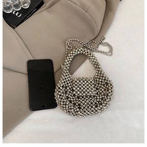 Detail of silver beaded woven handbag showing mini size compared to a smartphone