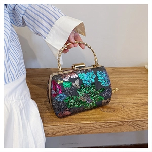 Detail der bunten Schmetterlings-Pailletten-Clutch mit goldenem Bambus-Metallgriff