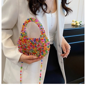 Detail of colorful acrylic beaded bag with a handheld ring and shoulder strap