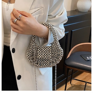 Close-up of a silver beaded evening bag with high-shine metallic finish and chain strap