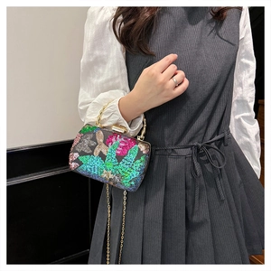 Close-up of sequin floral embroidery on box clutch with bamboo handle and chain strap