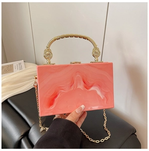 Detail of pink marble acrylic evening clutch with gold metal handle and chain strap