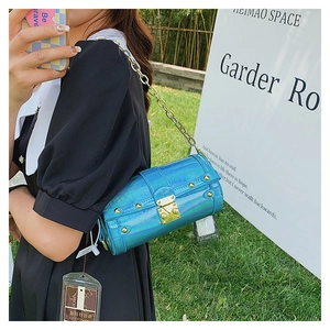 Détail du sac polochon bleu holographique embossé crocodile avec rivets et chaîne dorée