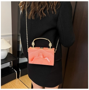 Detail of pink marble acrylic box bag with gold metal handle and chain shoulder strap