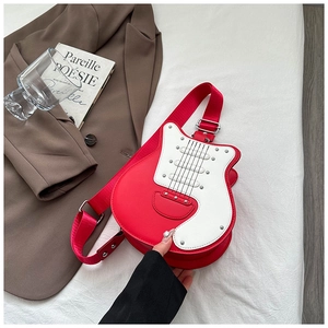 Detail view of red and white guitar-shaped crossbody bag with metal rivets and wide strap
