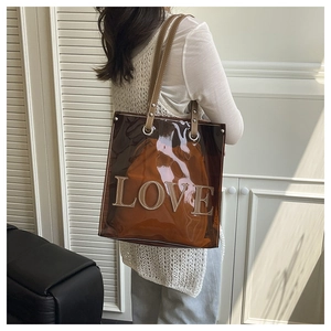 Detail der braunen transparenten Tasche mit LOVE-Schriftzug und orangefarbener Innentasche
