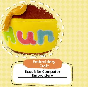 Close-up of computer embroidery on honey pot plush bag featuring vibrant HUN lettering