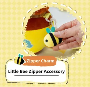 Detail of plush bee zipper pull with metallic chain and wings for crossbody bags