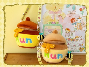 Close-up of cute plush honey pot bag featuring colorful Hun embroidery and bee charm